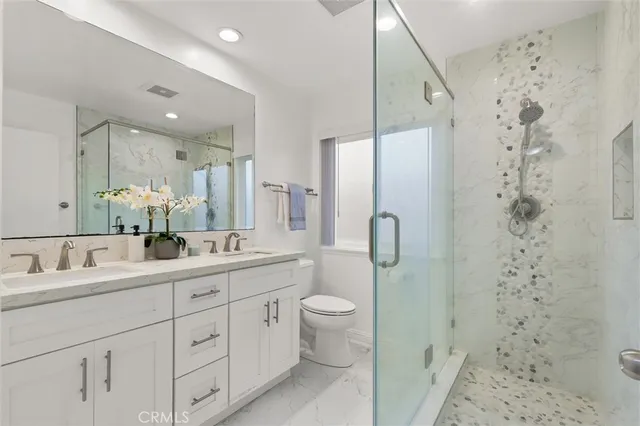 a bathroom with a double vanity sink mirror and shower