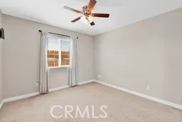 an empty room with window and ceiling fan