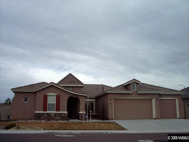 1687 Gemtown Drive Reno, NV 89521 - Photo 1 of 9 a front view of a house with a yard and garage