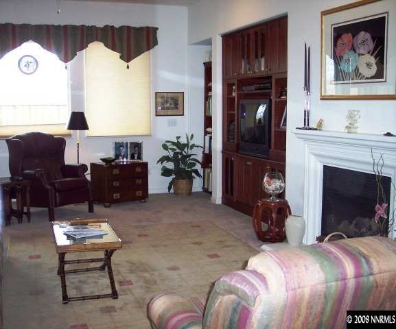1687 Gemtown Drive Reno, NV 89521 - Photo 6 of 9 a living room with furniture a fireplace and a table
