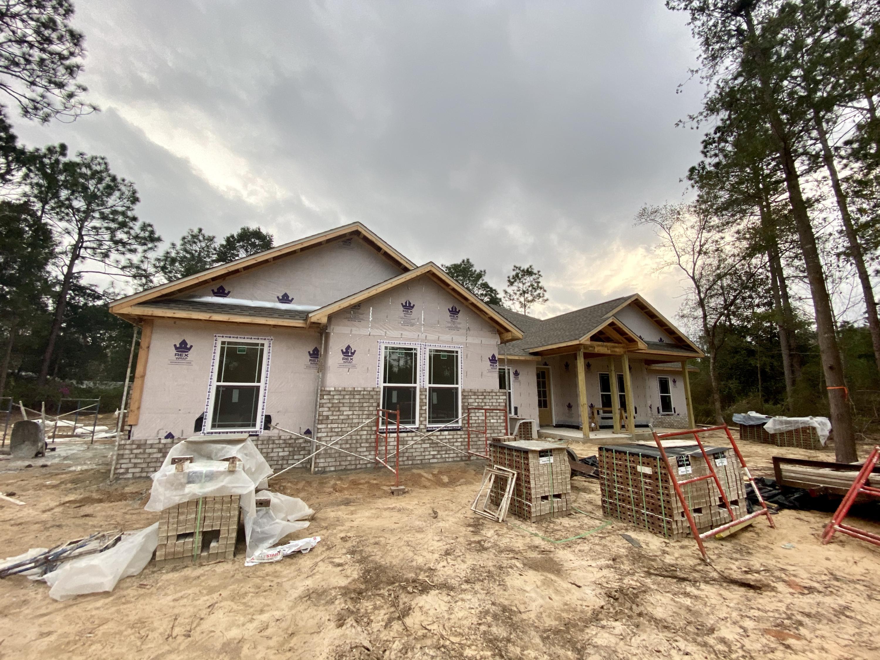 6080 Carina Road Crestview, FL 32539 - Photo 1 of 14 a view of a house with wooden deck and furniture