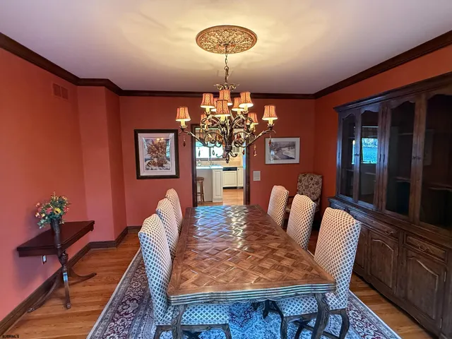 a kitchen with sink refrigerator dining table and chairs