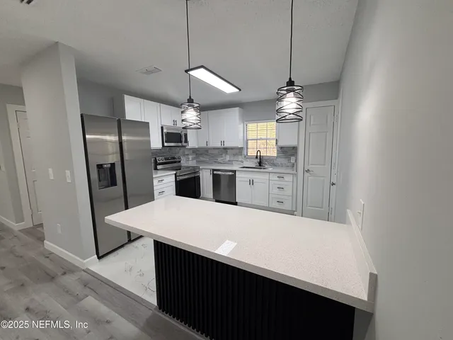 a large kitchen with a refrigerator a sink and a stove