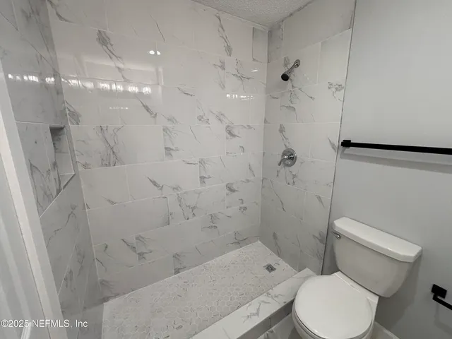 a white toilet sitting next to a bath tub shower