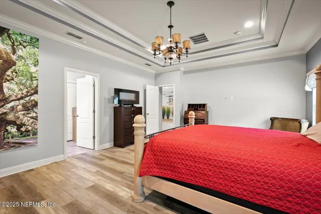 a bedroom with a bed and a chandelier