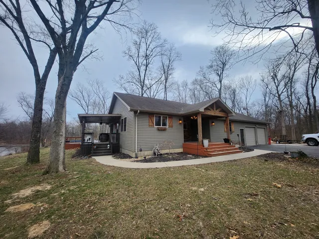 a view of a house with large trees and wooden fence