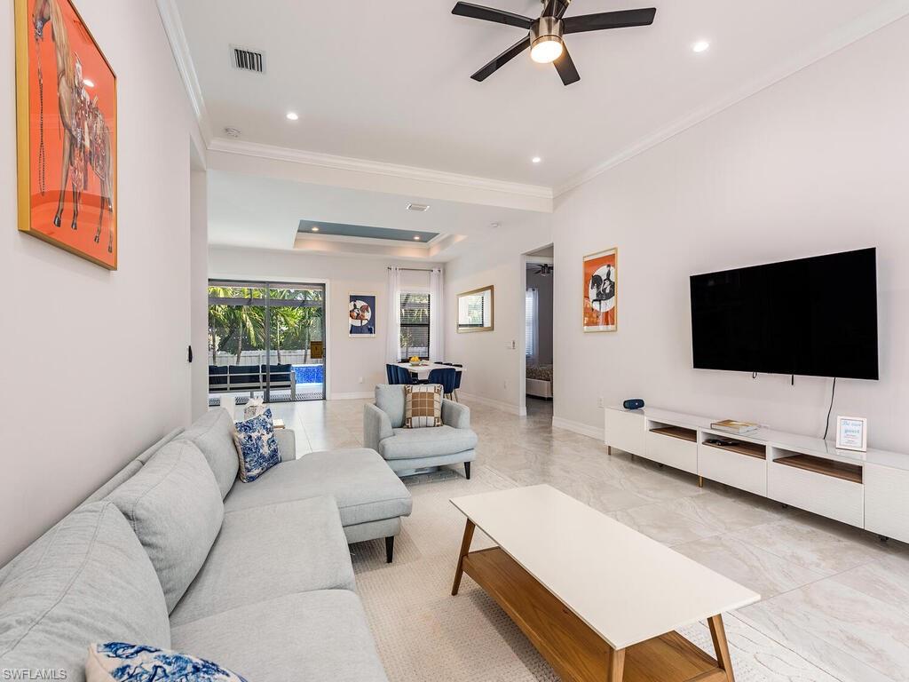 1021 Creech Road Naples, FL 34103 - Photo 3 of 12 Living area with ornamental molding, ceiling fan, light tile patterned flooring, a raised ceiling, and recessed lighting