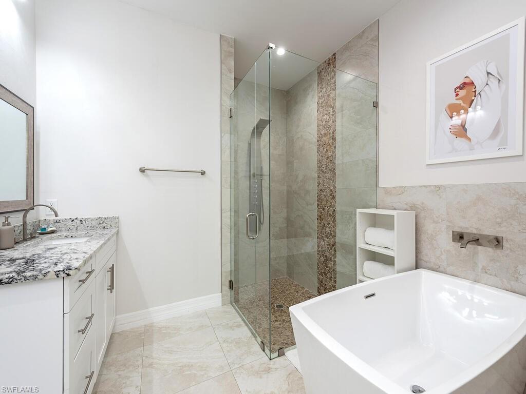 1021 Creech Road Naples, FL 34103 - Photo 7 of 12 Full bath featuring vanity, a soaking tub, and a stall shower