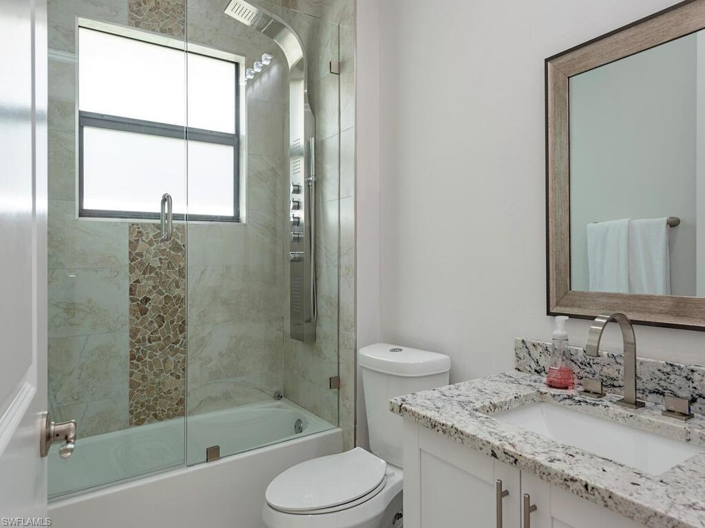 1021 Creech Road Naples, FL 34103 - Photo 9 of 12 Full bathroom with shower / bath combination with glass door and vanity