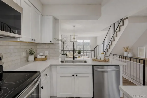 a kitchen with stainless steel appliances granite countertop a sink a stove and cabinets