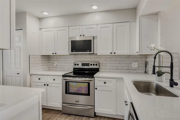 a kitchen with appliances a sink and cabinets