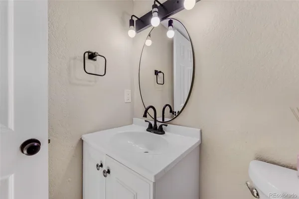 a bathroom with a sink a toilet and mirror