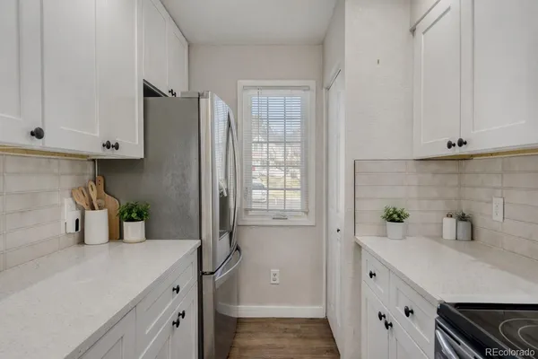 a kitchen with stainless steel appliances white cabinets and a window