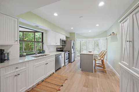 a kitchen with a table chairs sink microwave and cabinets