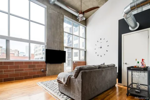 a living room with furniture a flat screen tv and a floor to ceiling window
