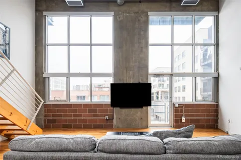 a living room with furniture a flat screen tv and a window