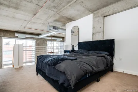 a spacious bedroom with a bed and large windows