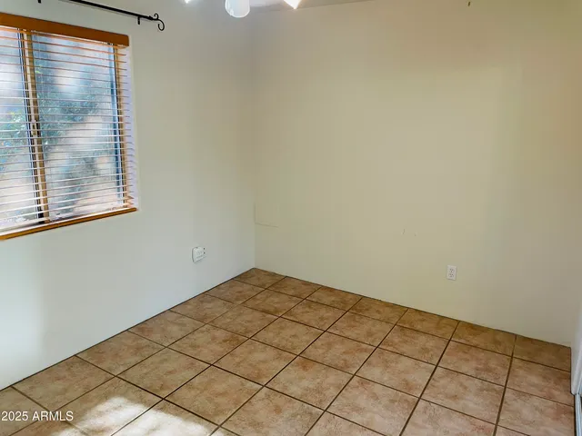 a view of a small space with wooden floor and a window