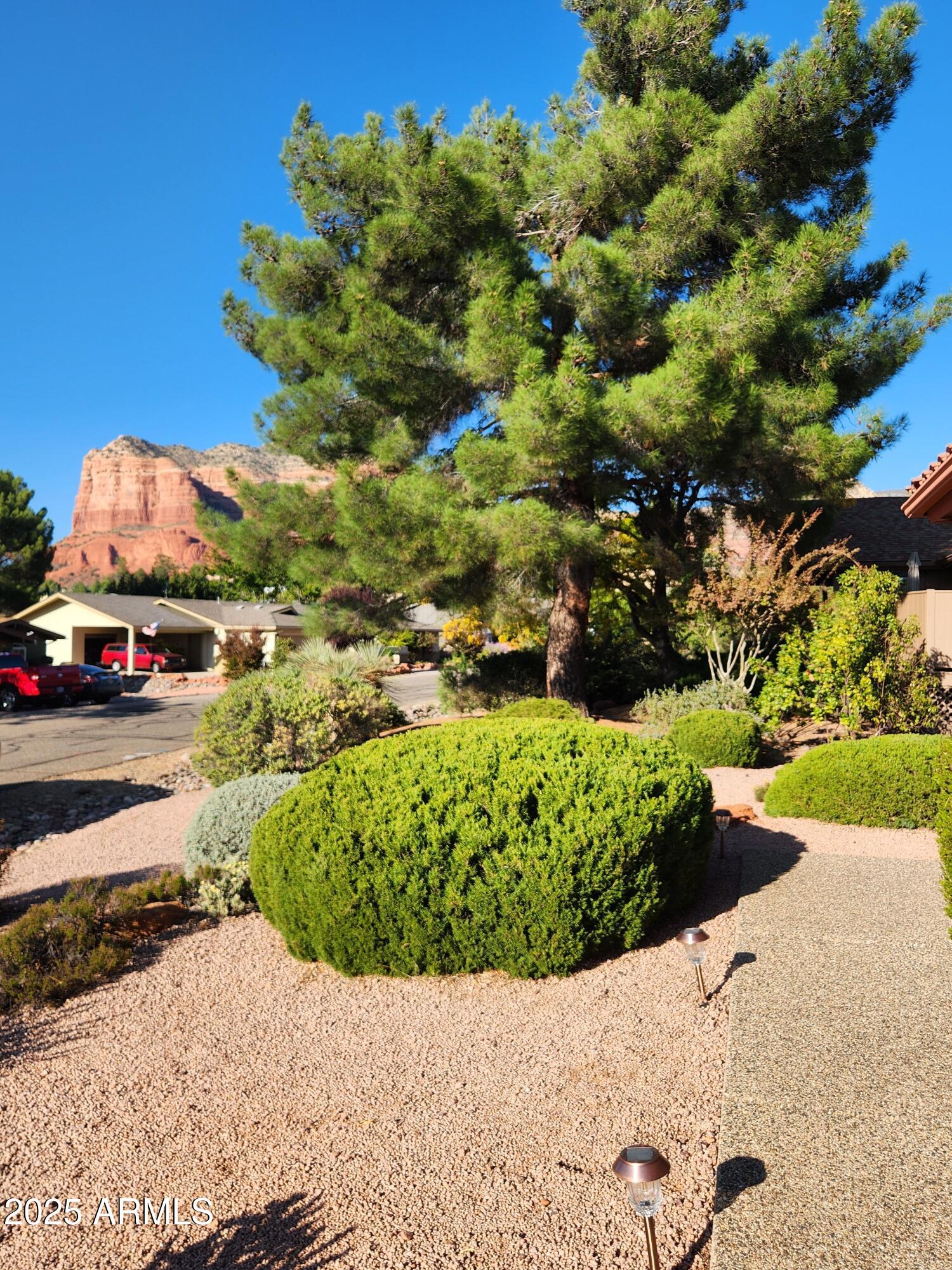 80 Stone Way Sedona, AZ 86351 - Photo 4 of 20 a view of a garden with a lot of flower plants and wooden fence