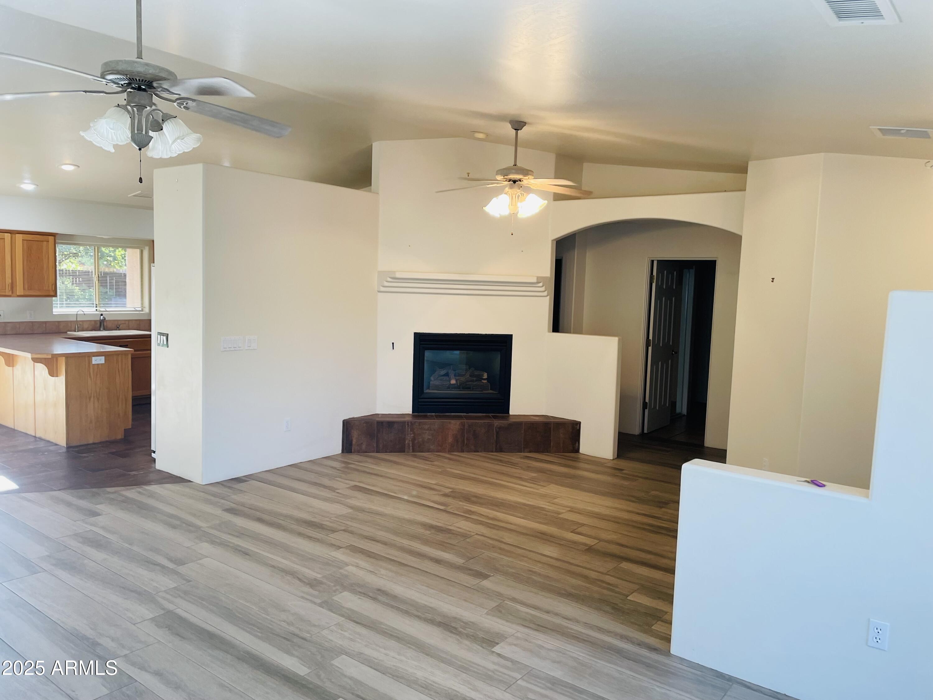 80 Stone Way Sedona, AZ 86351 - Photo 5 of 20 a view of an empty room with a fireplace and a kitchen view