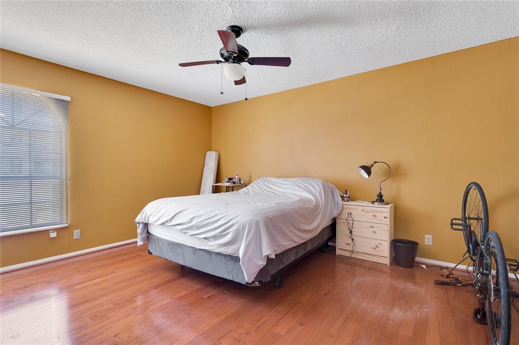 910 Duncan Lane, Unit 35 Austin, TX 78705 - Photo 11 of 20 Hardwood flooring extends throughout this naturally illuminated bedroom with a ceiling fan for comfort.