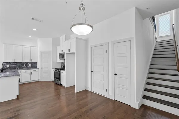 a view of a kitchen with refrigerator and wooden floor