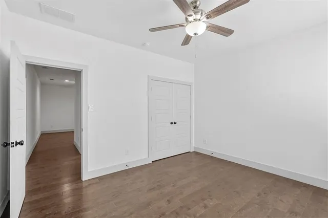 an empty room with a ceiling fan and a fan