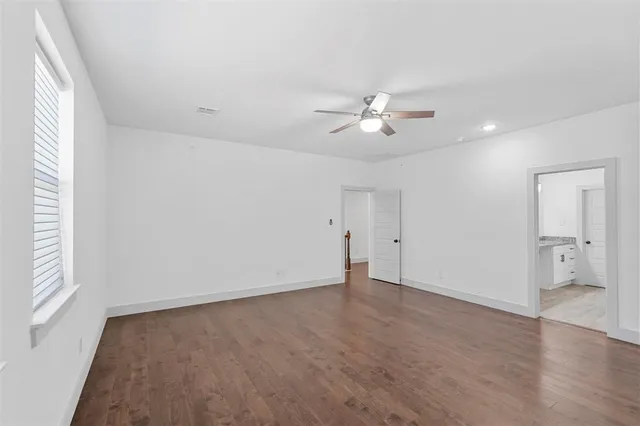 an empty room with a window and a ceiling fan