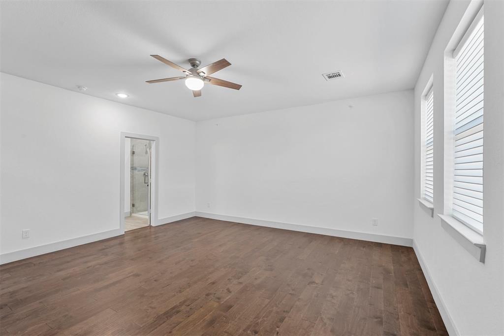 6059 Rivendell Drive Frisco, TX 75035 - Photo 26 of 30 an empty room with wooden floor ceiling fan and windows