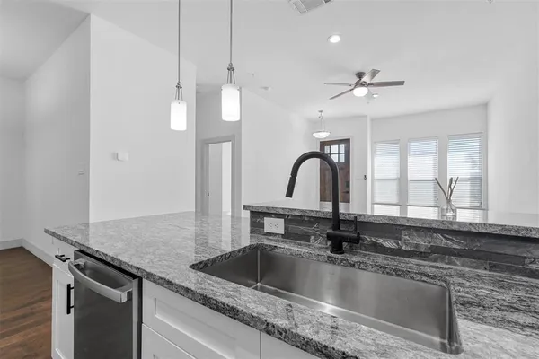 a kitchen with a sink a counter top space cabinets and stainless steel appliances