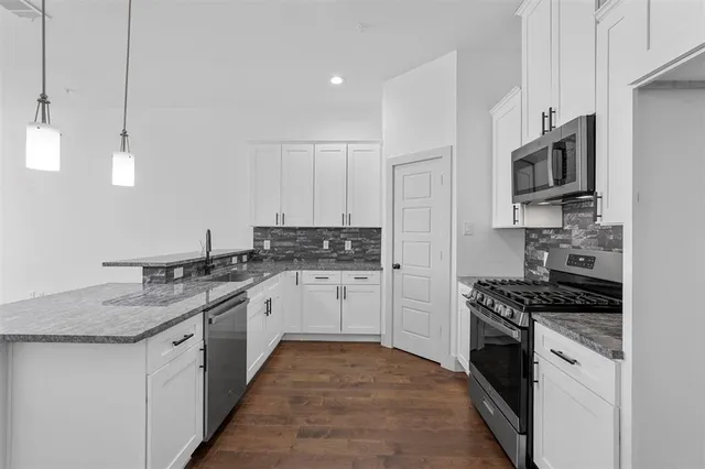 a kitchen with stainless steel appliances granite countertop a sink stove and microwave