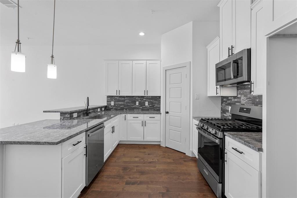 6059 Rivendell Drive Frisco, TX 75035 - Photo 8 of 30 a kitchen with stainless steel appliances granite countertop a sink stove and microwave