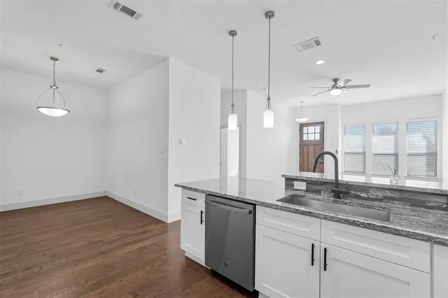 a kitchen with granite countertop white cabinets and white appliances