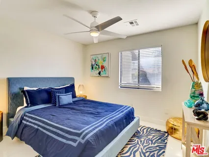 a bedroom with a bed and a painting on the wall