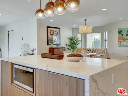 a kitchen with a sink a counter space and a dining table