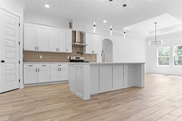 a large kitchen with cabinets and wooden floor