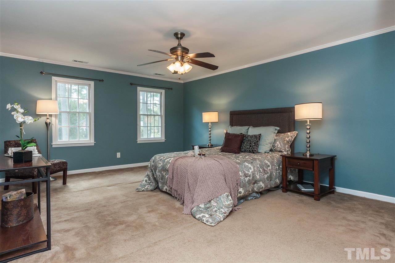 7205 Sawbuck Court Raleigh, NC 27613 - Photo 15 of 25 a bedroom with a bed and a chandelier