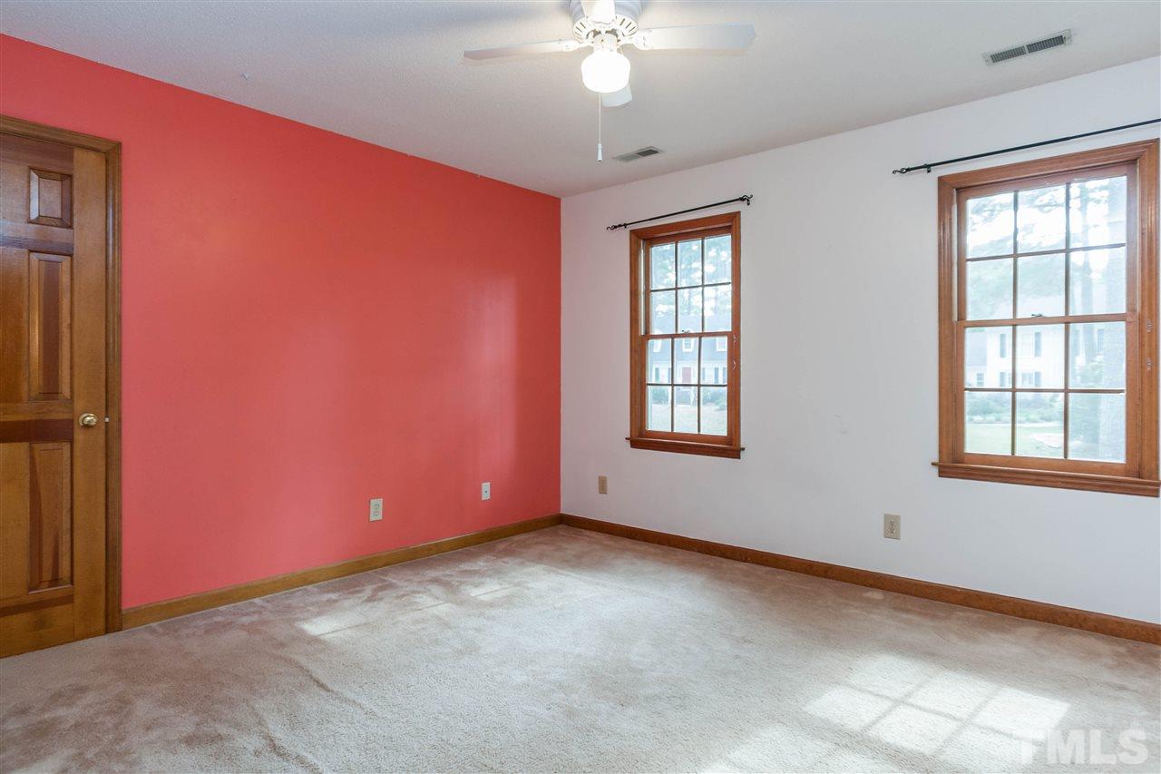7205 Sawbuck Court Raleigh, NC 27613 - Photo 20 of 25 an empty room with windows and chandelier fan