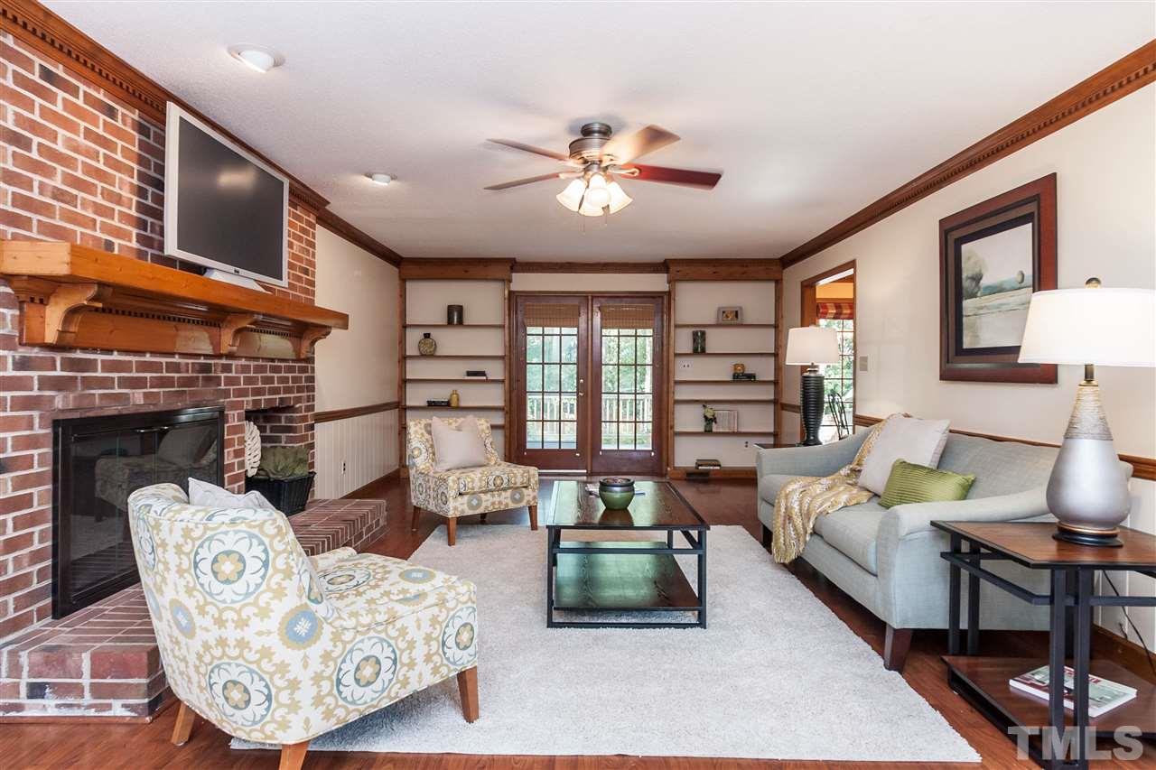 7205 Sawbuck Court Raleigh, NC 27613 - Photo 3 of 25 a living room with furniture a fireplace and a large window