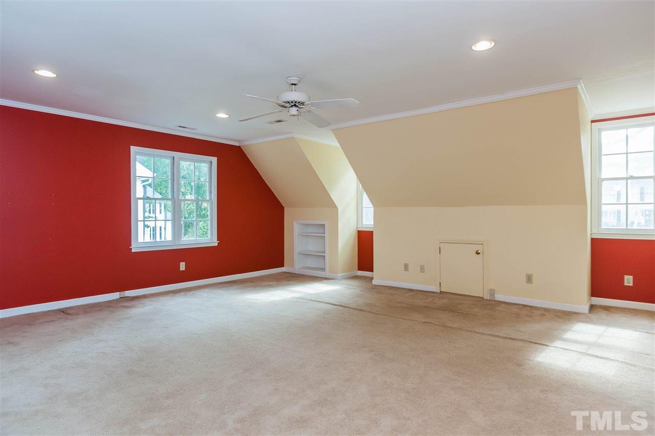 7205 Sawbuck Court Raleigh, NC 27613 - Photo 22 of 25 an empty room with windows and chandelier fan
