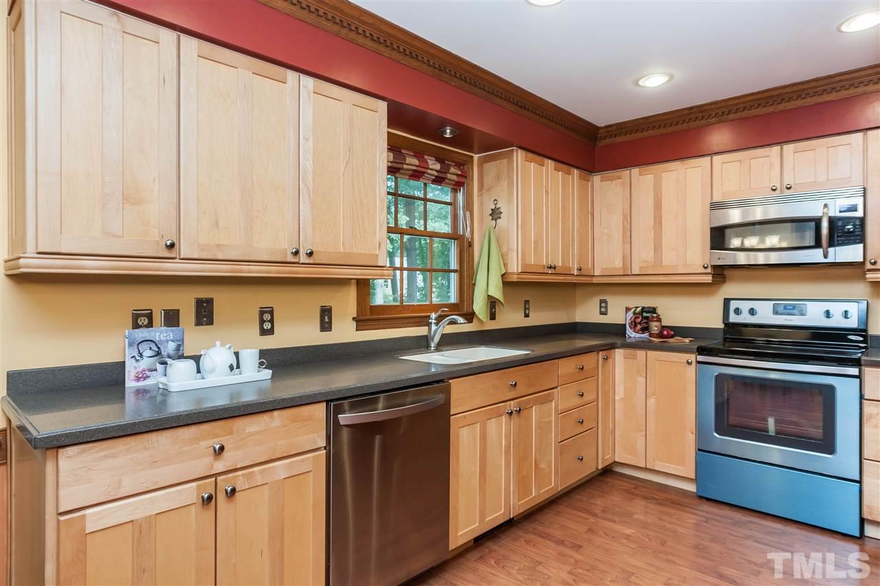 7205 Sawbuck Court Raleigh, NC 27613 - Photo 10 of 25 a kitchen with stainless steel appliances granite countertop a stove a sink and a microwave