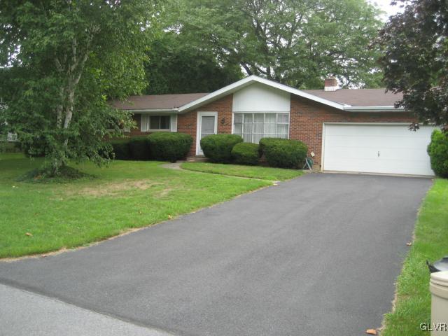 a front view of house with yard and green space