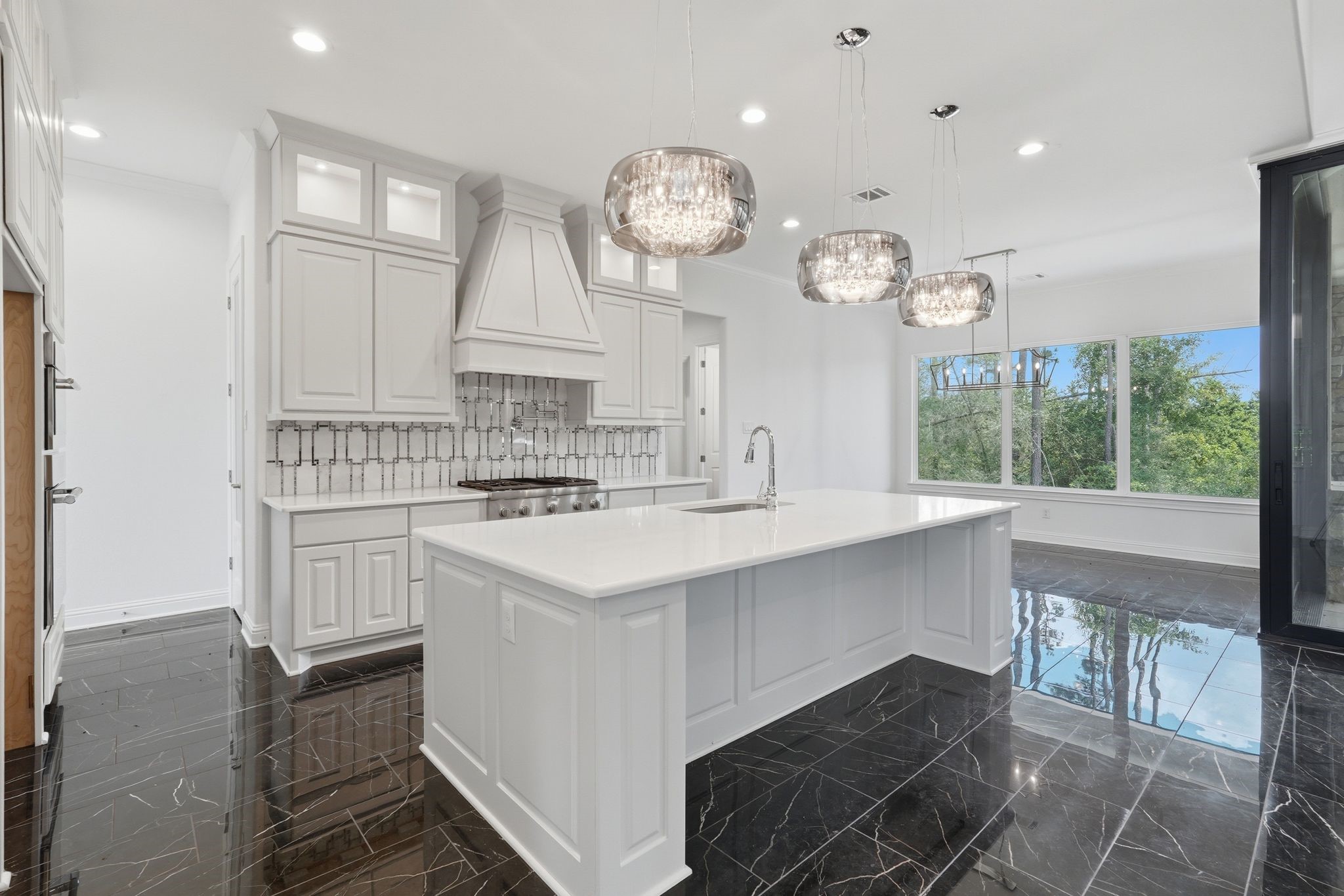 16081 Forest Mill Road Willis, TX 77378 - Photo 13 of 37 Beautiful quartz countertops, designer lighting, and an oversized island make this kitchen the heart of the home.