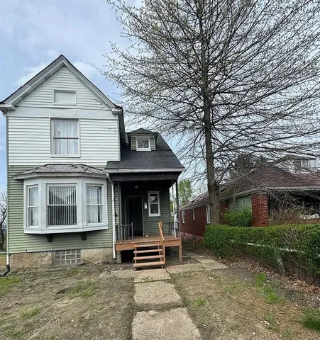 a view of a house with a patio and a yard