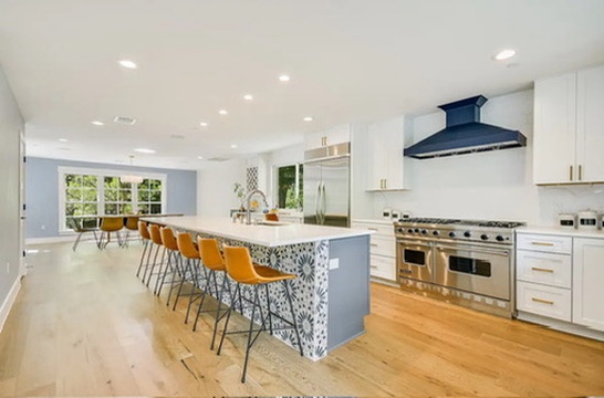 2007 Manana Street Austin, TX 78730 - Photo 28 of 38 Kitchen featuring white cabinetry, an island with sink, premium appliances, custom range hood, and a kitchen bar