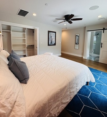 2007 Manana Street Austin, TX 78730 - Photo 31 of 38 Bedroom featuring a barn door, ensuite bath, recessed lighting, a ceiling fan, and wood finished floors