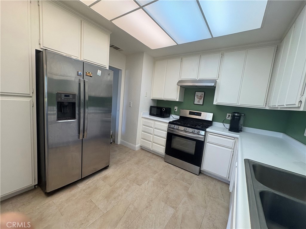 26168 Birkdale Road Menifee, CA 92586 - Photo 6 of 15 a kitchen with granite countertop a refrigerator and a stove