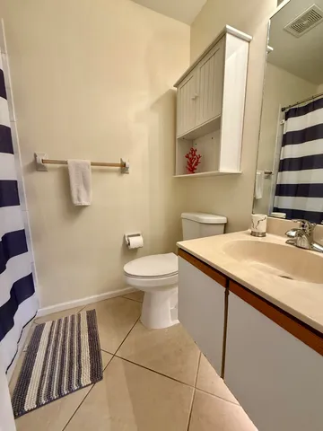 a bathroom with a sink a toilet a mirror and shower