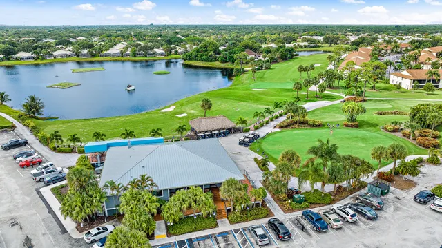 an aerial view of a house with a garden and lake view
