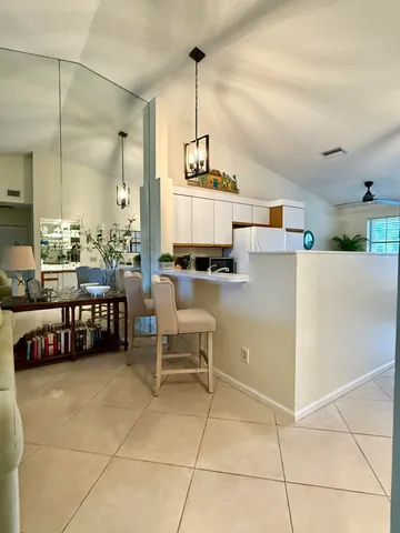 a living room with couches and kitchen view with wooden floor